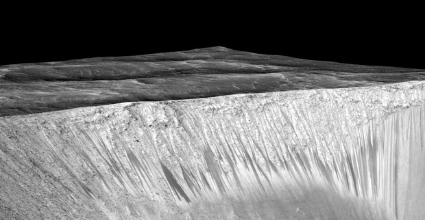 A simulated topographic image of dark streaks formed by water running down the walls of Garni Crater on Mars. The image is constructed from imagery from the Mars Reconnaissance Orbiter. Image: NASA/JPL-Caltech/University of Arizona.