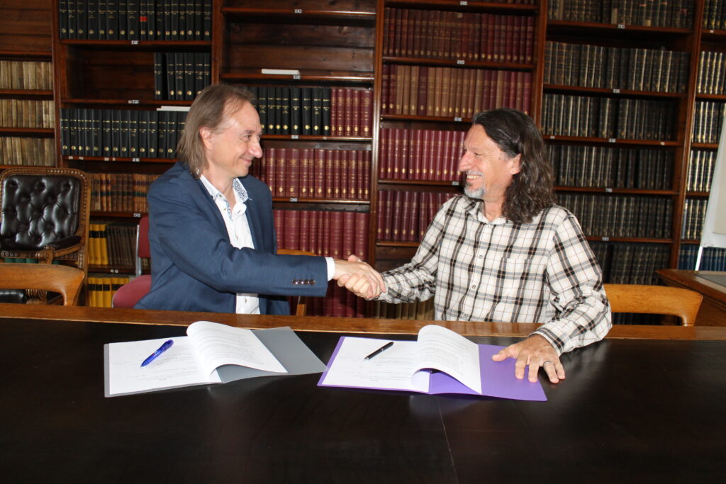Stuart Clark and Steven Young shake hands after signing the Astronomy Now contract.