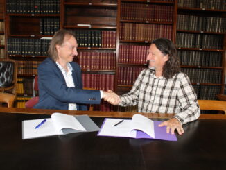 Stuart Clark and Steven Young shake hands after signing the Astronomy Now contract.